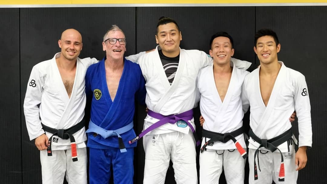 Photo with instructors and new purple belt Adam after awarded blue belt