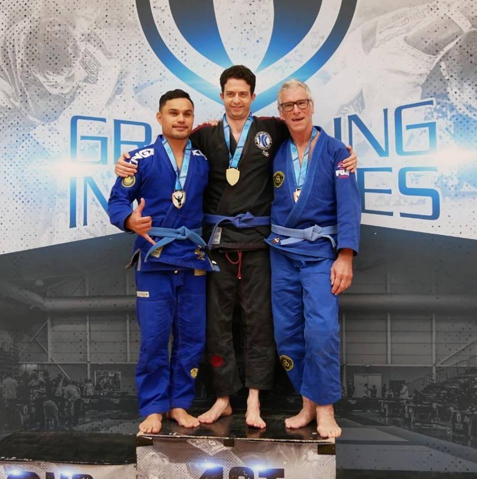 Photo with three men
                                          standing together on podium at Grappling Industries